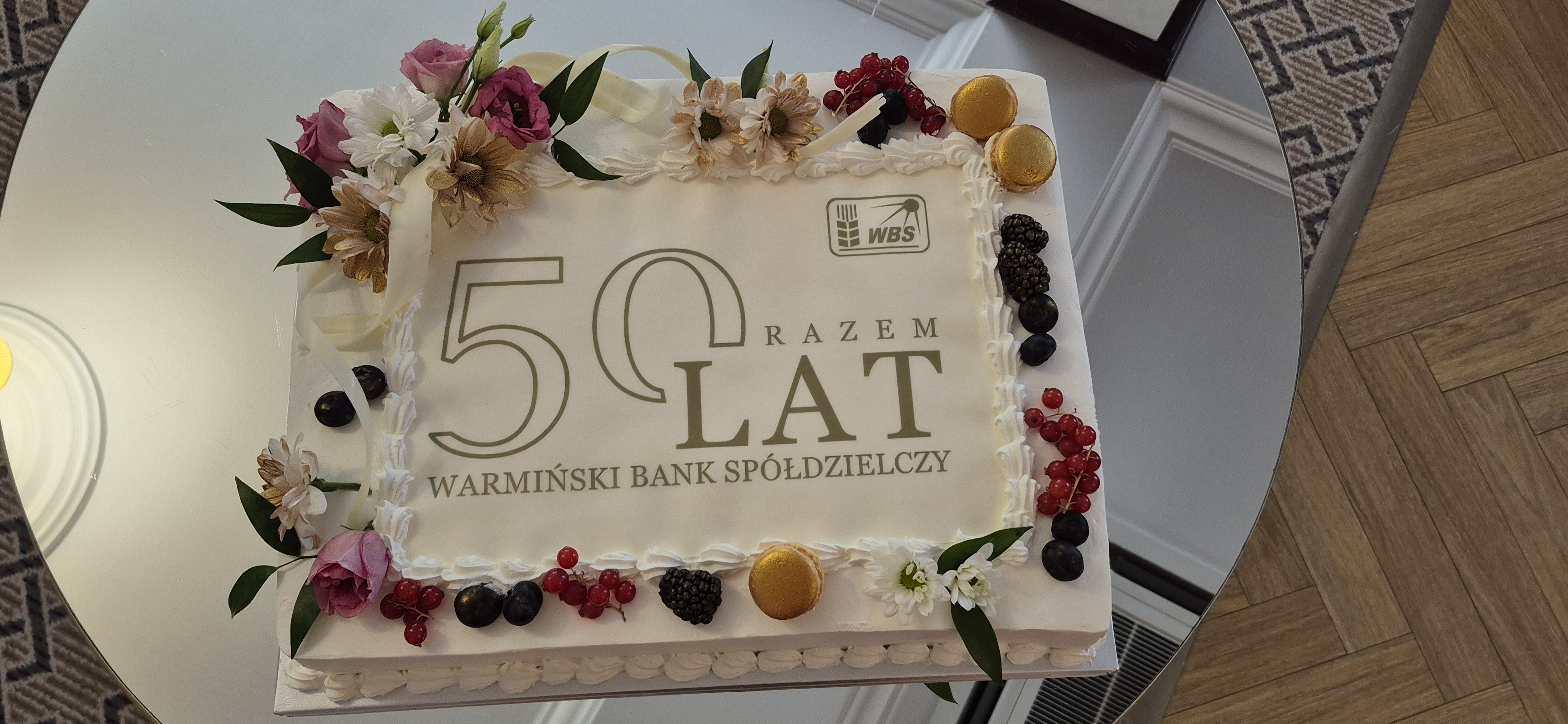 tort z logo banku owocami i dekoracjami