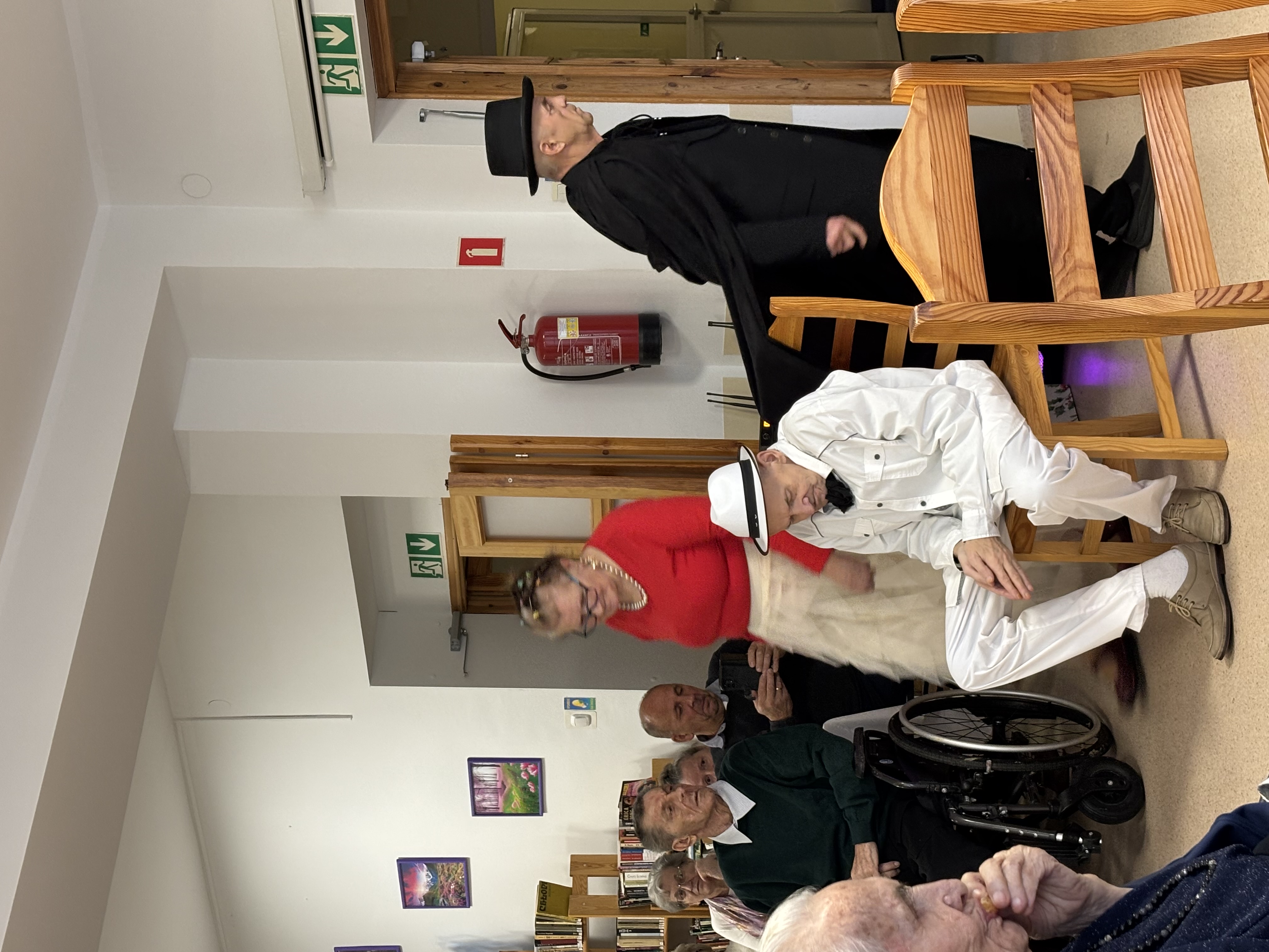 Zdjęcie ze sztuki - człowiek na krześle oraz dwie postacie stojące nad nim